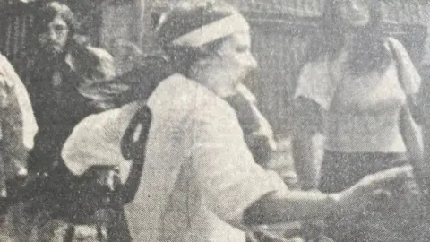 Pat Michell-Firth A black and white image of Pat Mitchell-Firth on the football pitch. She is wearing a white shirt with the number nine on the back