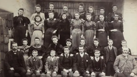 Belper North Mill Trust Black and white photograph of Belper Mill male and female workers dressed smartly in suits and dresses in 1896.