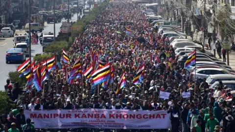 Reuters A large gathering in Manipur's capital city Imphal on 31 January 2026, with people waving flags and demanding a resolution of the conflict. 