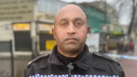 A head and shoulders photo of Supt Deepak Kenth, a man of asian heritage, wearing a black police uniform