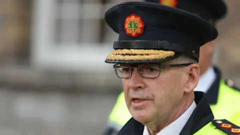 PA Media Garda Commissioner Drew Harris speaking to the media at Garda headquarters in Dublin after Irish police officer Kevin Flatley was killed at a checkpoint in Dublin after being struck by a motorbike. He is wearing his garda hat and glasses.