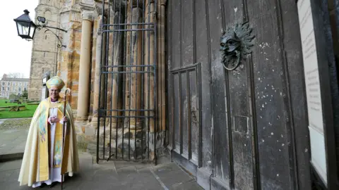 PA Justin Welby outside Durham Cathedral wearing church clothes and holding a crozier.