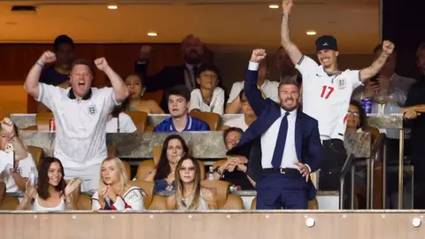 Getty Images David Beckham celebrates an England goal from his family box in Miami while Victoria stays calmly seated