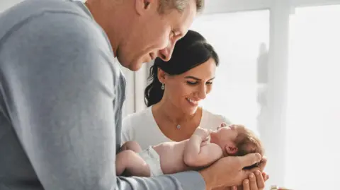 A couple holding a baby.