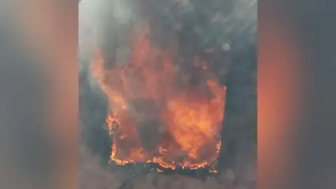 Handout Huge orange flames rising from an upstairs window. 