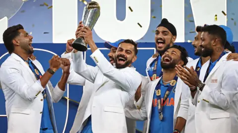 India players wearing their tailored white jackets as they lift the Champions Trophy