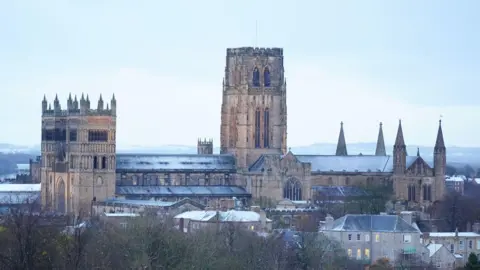 Durham Cathedral, made up of ancient buildings, covered in a scattering of snow.