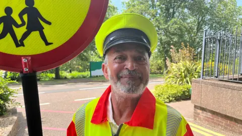 A smiling man with a beard wearing high-vis uniform