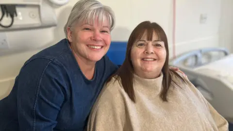 BBC Two women, one with blonde/silver hair, and the other with brown hair posing for a photo in a hospital room
