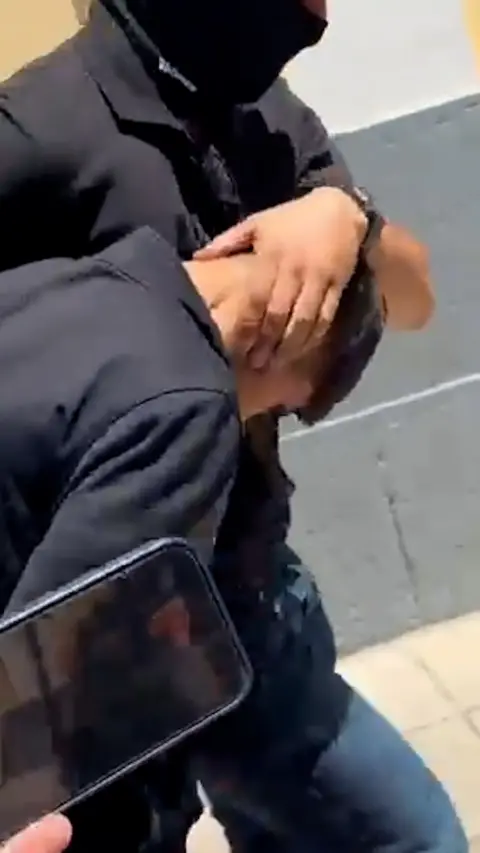 Man being held by the head by police