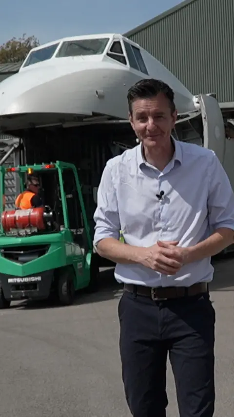 A man standing in front of a large aircraft