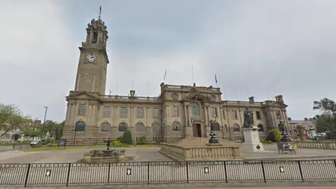 Google South Tyneside Council headquarters, a large sandstone building with a clock tower and statues and balustrades to the front.