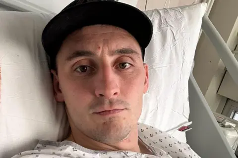 Sam Davies Sam Davies lying on a hospital bed 