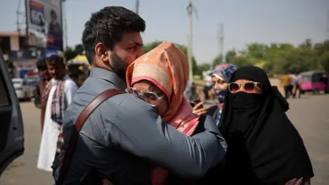 Reuters Pakistan citizen Sahibzada Munadi Ahmad, who recently married Indian Zakiya Firdous, hugs his wife goodbye as he prepares to leave India after India revoked all visas issued to Pakistani citizens, at the Attari-Wagah border crossing near Amritsar, India, April 25, 2025.