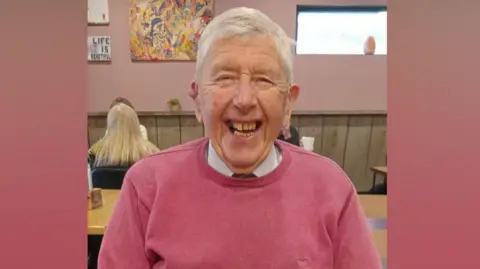 Joe McCambridge, an elderly man with grey hair. He is laughing in the photo.