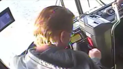 Passenger sitting behind wheel in driver's seat