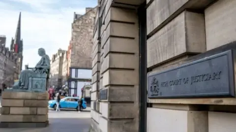 BBC The exterior of the High Court in Edinburgh. A sign on the wall says High Court of Justiciary