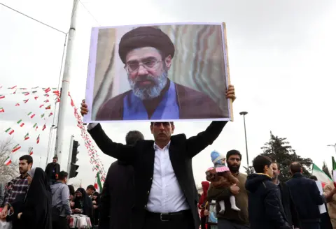 EPA An Iranian man holds a picture of Mojtaba Khamenei as he takes part in celebrations of the 47th anniversary of the Islamic Revolution in Tehran, Iran, 11 February 2026.