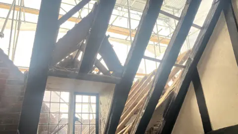 Adrian Harms/BBC The roof of Cranleigh Cottage Hospital which is currently undergoing renovations. A number of beams are visible and scaffolding can be seen on the outside. 