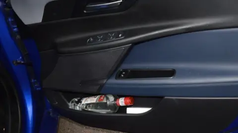 Bedfordshire Police A bottle of vodka lying on its side in a vehicle's door pocket. 