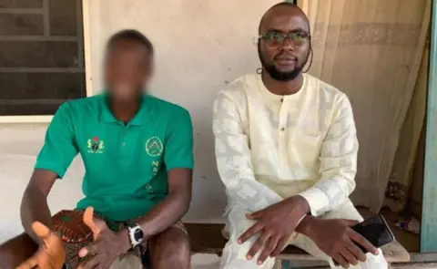 Advocate for accused witches Jude (left) sits wearing a green T-shirt with his face blurred and Dooyum Dominic Ingye (right) in a cream outfit