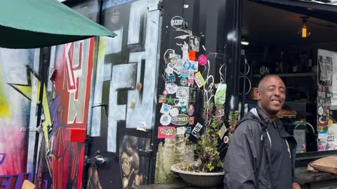 Markos se paró frente a su cafetería.