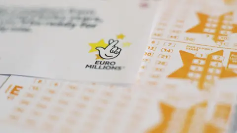 PA Media White and yellow Euromillions lottery slips seen stacked up