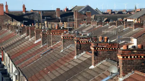 PA Media Image shows the rooftops of rows of terraced houses