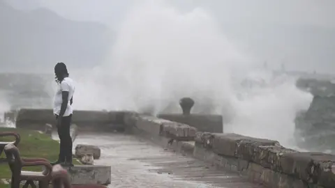 Getty Images A man stands in front of a stormy sea