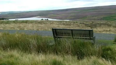 Part of the Waskerley Way path. The path is gravel and overlooks a lake. A wooden bench has been installed next to the route so visitors can enjoy the view.