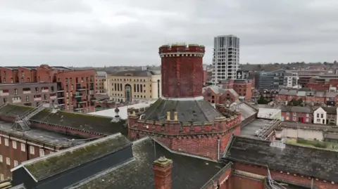 A general view picture of the top of Reading Prison's brick turret, with other parts of the prison around it.