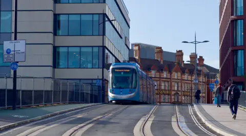 Image shows a tram travelling through Wolverhampton city centre