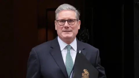 Reuters Sir Keir Starmer holds an official black government folder on the steps of 10 Downing Street