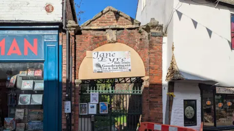 Julie Mariotti/BBC The gate on Goodramgate leading to Holy Trinity Church. The top half of the gate is boxed to keep pieces of concrete from hitting visitors. 