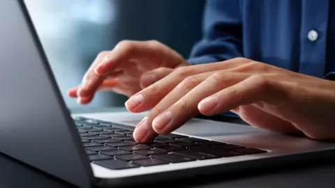 Close shot of hands typing on silver laptop
