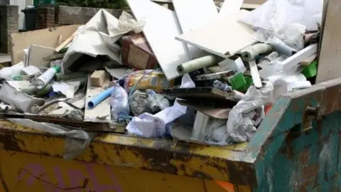 A skip full of discarded builder's waste.