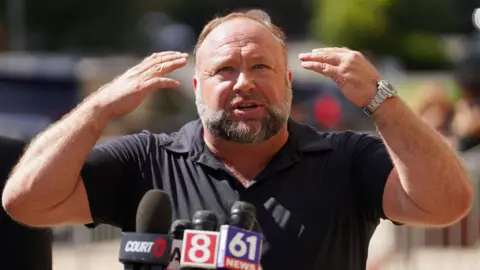 Getty Images InfoWars founder Alex Jones speaks to the media outside Waterbury Superior Court during his trial on 21 September, 2022 in Waterbury, Connecticut. 