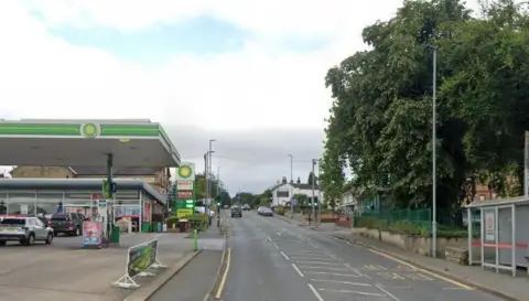 The A628 Barnsley Road in Ackworth, with trees and a bus stop on the right and a BP garage with green signage on the left.