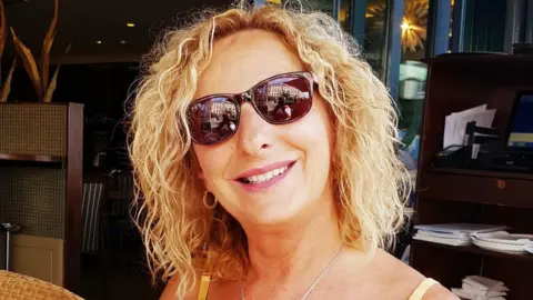 Sheena Ferrand Sheena Ferrand with medium length blonde hair, wearing sunglasses.