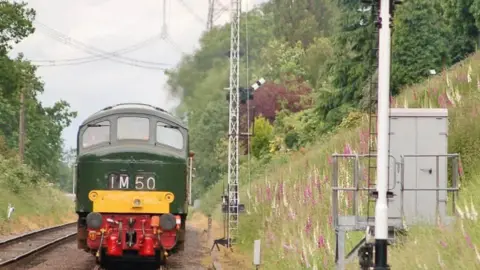 Great Central Railway A train on a railway track with a grass verge on the right. 
