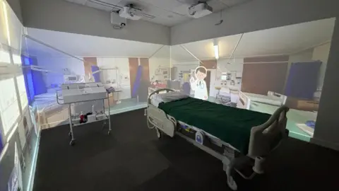 University of Bedfordshire A mocked-up hospital room, including a bed and equipment, inside the new training facility