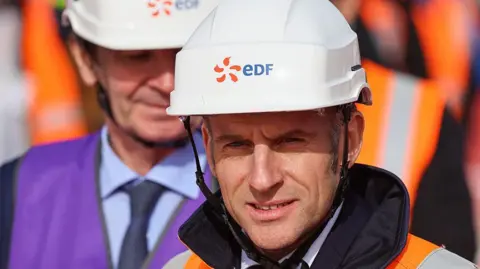 AFP A man in a hard hat and orange jacket