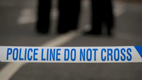 White and blue police tape, reading: "Police line do not cross".