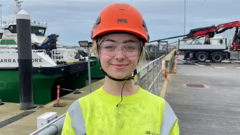 Ben Schofield/BBC Jovita Beeston standing on the quayside at the Port of Lowestoft