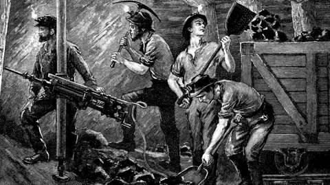 Getty Images A black and white sketch showing four men digging for coal in an underground mine. One is drilling at the walls using machinery, while the others load a wooden trolley full of coal from a pile on the ground. Another uses a pick axe to chip away at the wall. They are all wearing helmets with lights attached to the front. 