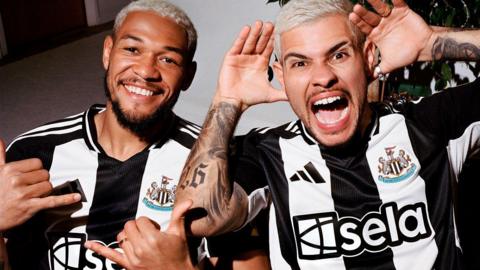 Newcastle United players Joelinton and Bruno Guimaraes model the team's new home shirt