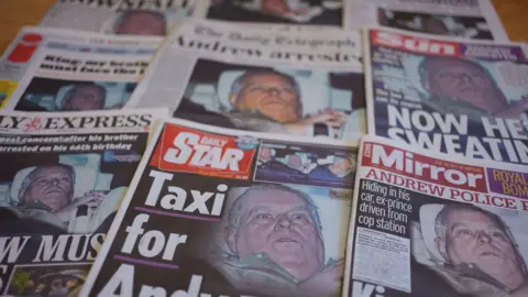 PA Media Nine newspapers stacked in rows of three on a table. On the front covers of all of them is the photo of Andrew looking shocked.