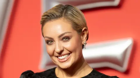 Amy Dowden sporting short blonde hair and smiling at the camera.