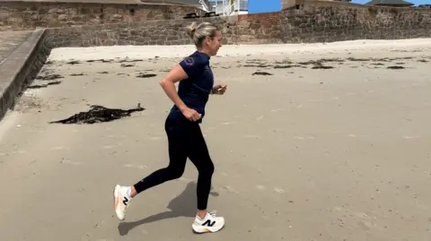 A woman running on a beach.