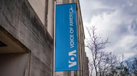 Blue signage of Voice of America seen outside its headquarters in Washington, DC